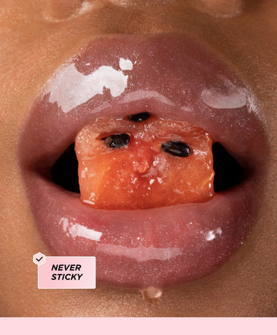 Glossy lips surrounding a piece of watermelon.