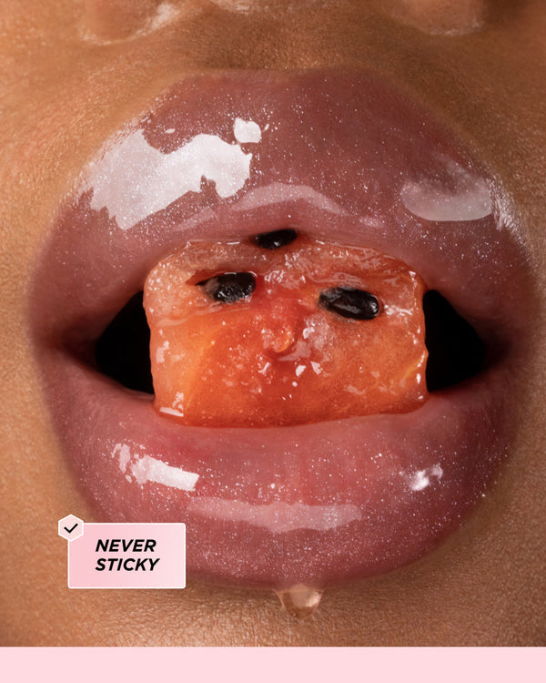 Glossy lips surrounding a piece of watermelon.
