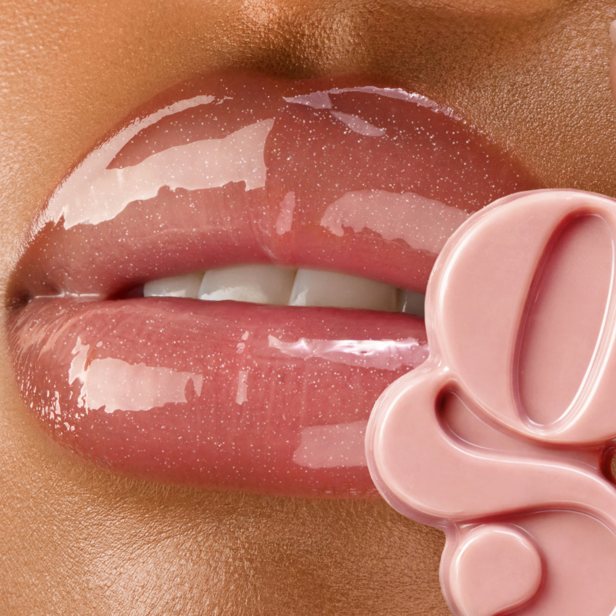 Close-up of a Gisou Honey Infused Lip Oil wand applying gloss to glossy pink lips.