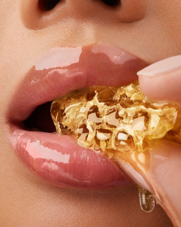 Close up of a mouth eating honeycomb.