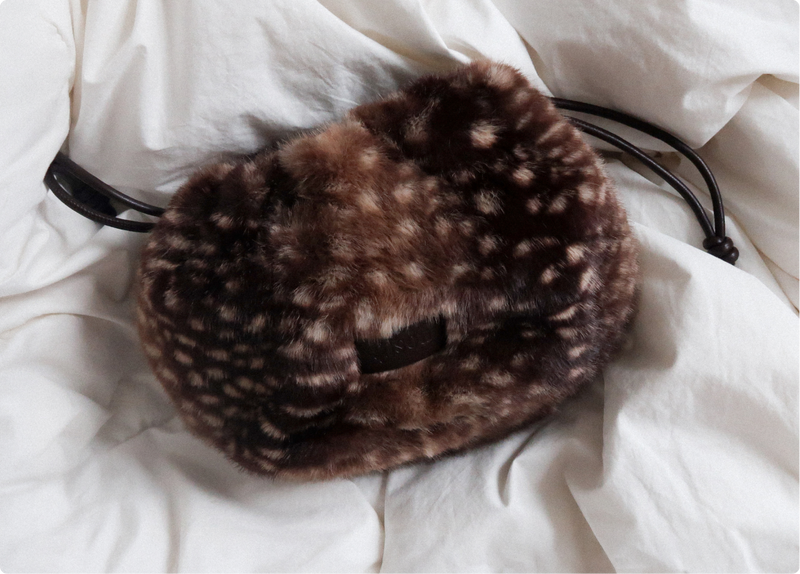Gisou Honey Fluff Pouch in fawn-print faux fur on white sheets