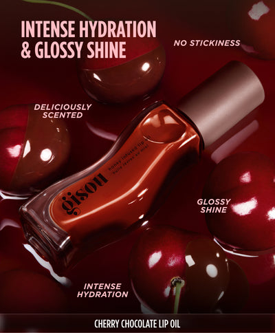 Close-up of glossy lips biting into a cherry stem, promoting the Gisou Cherry Chocolate Lip Oil.
