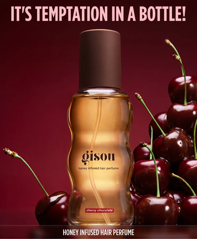 Gisou Cherry Chocolate hair perfume bottle surrounded by cherries on a dark red background, labeled 