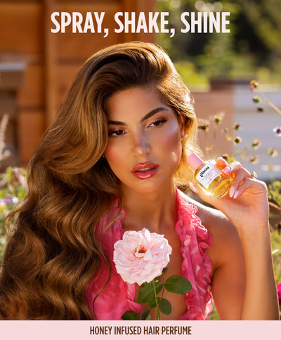 Model in a garden holding Wild Rose hair perfume, 