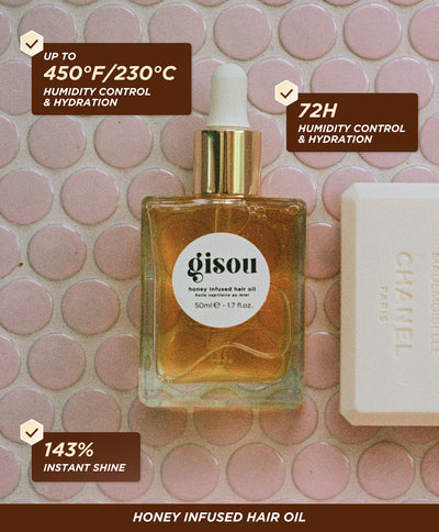 Gisou Honey Infused Hair Oil 50ml displayed on a tiled surface with benefit callouts highlighting heat protection up to 450°F /230°C, 72h humidity control and 143% instant shine.