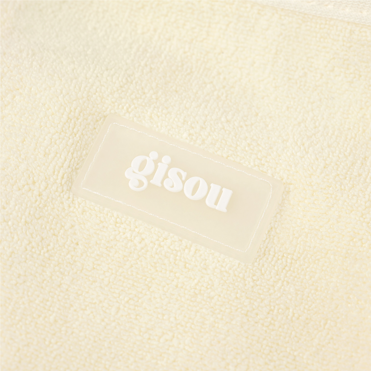 Close-up of Honey Glow Hair Towel embossed with the Gisou logo