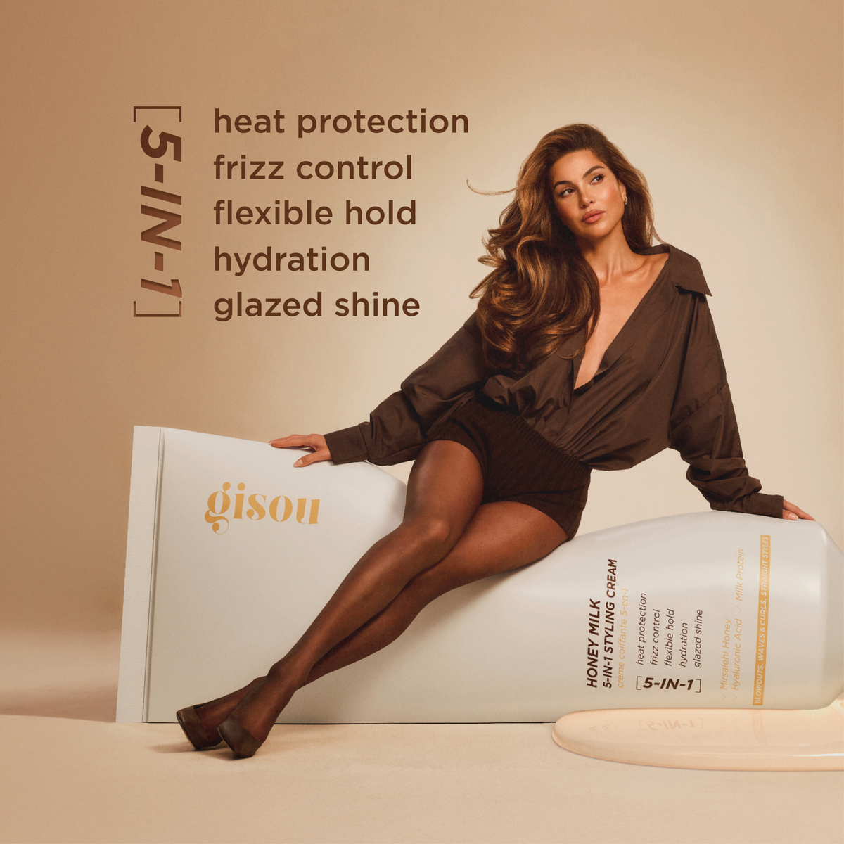 Model with voluminous curled hair next to Gisou Honey Milk 5-in-1 Styling Cream, listing benefits: heat protection, frizz control, flexible hold, hydration, and glazed shine.