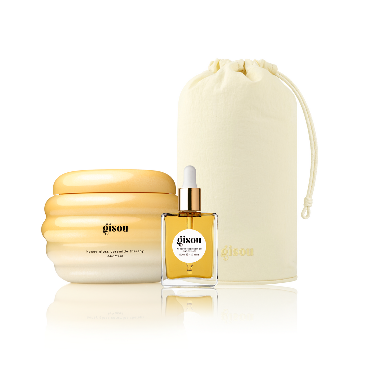 Gisou Honey Gloss Ceramide Therapy Hair Mask, Gisou Honey Infused Hair Oil, and a Gisou Honey Glow Hair Towel pouch grouped together on white.