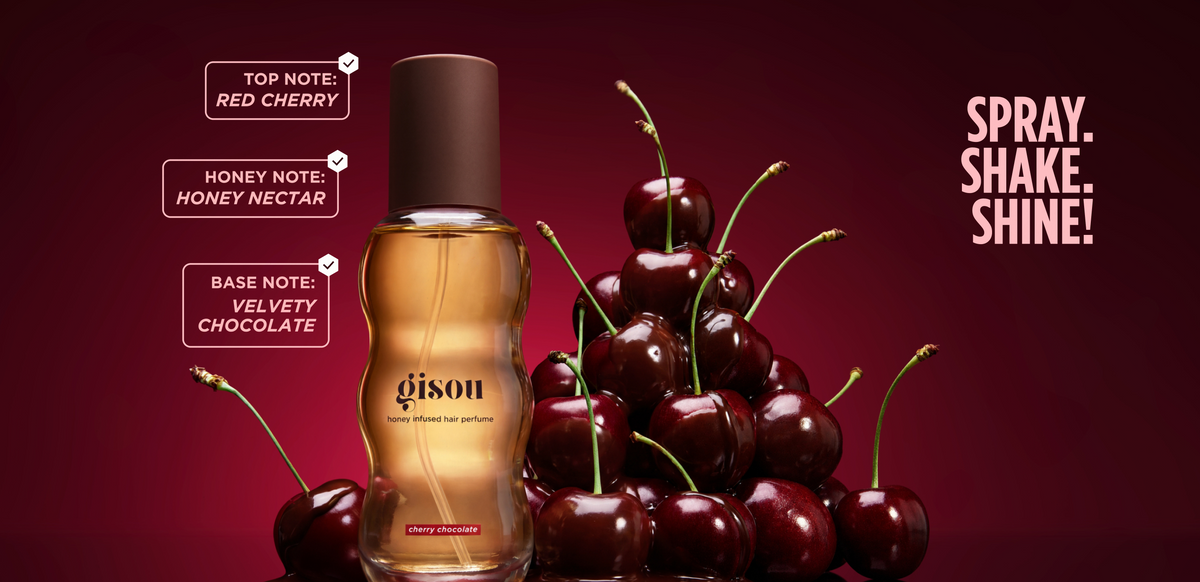 New Gisou Hair Perfume in Cherry Chocolate placed next to cherries with chocolate.