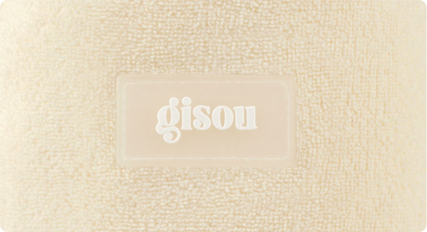 Close-up of Honey Glow Hair Towel embossed with the Gisou logo.