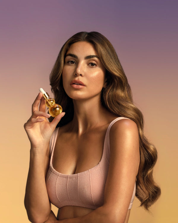 Gisou Founder holding a bottle of the Honey Infused Face Oil