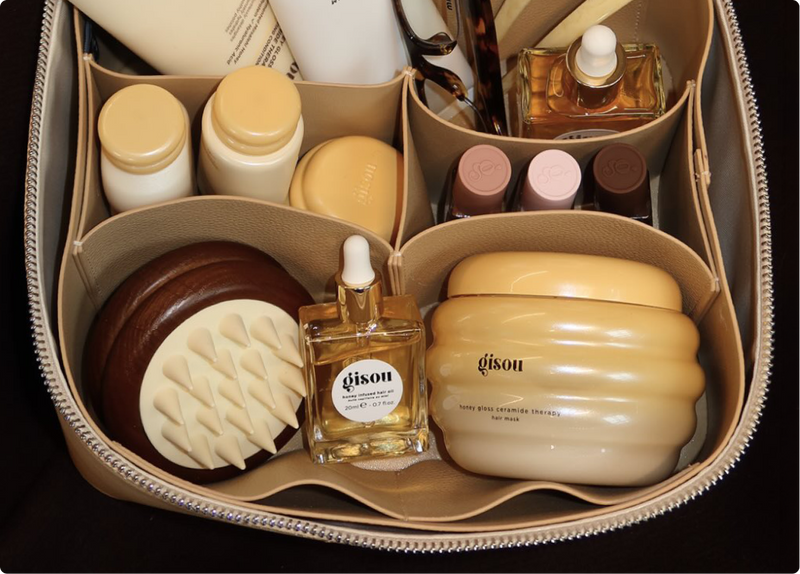 Gisou travel case packed with hair oil, mask, brush, and mini bottles.