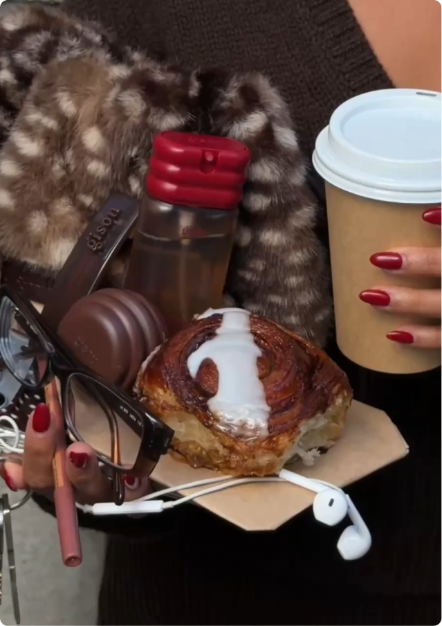 Gisou items tucked in a bag alongside a coffee and pastry