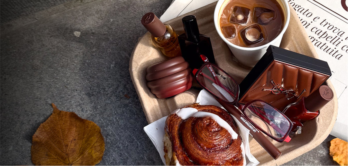Gisou hair perfume, lip oil and lip mask on a tray with iced coffee and a cinnamon bun