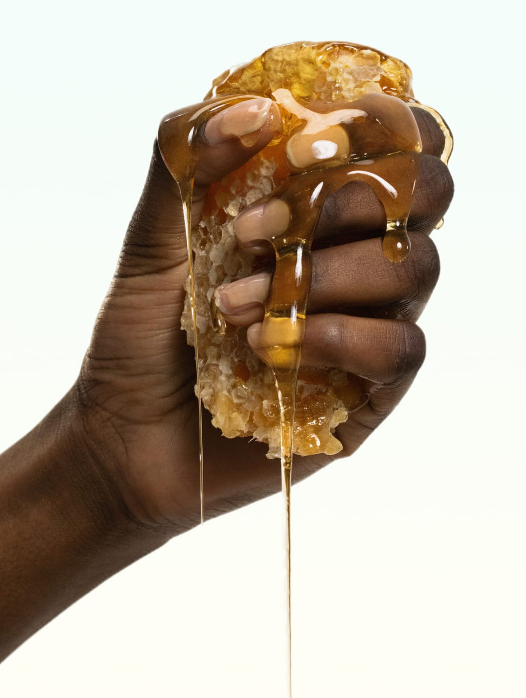 Close up of model squishing honey comb 