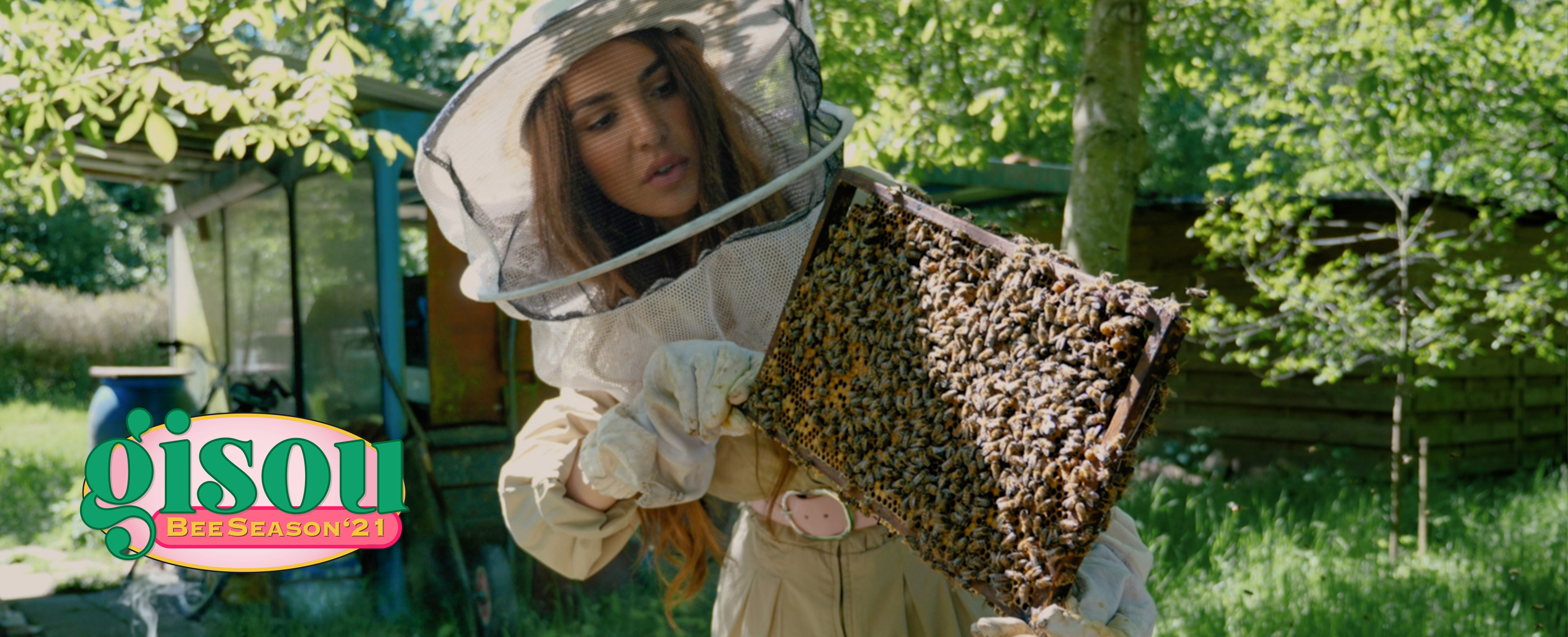 Negin in the bee garden holding a tray of bees
