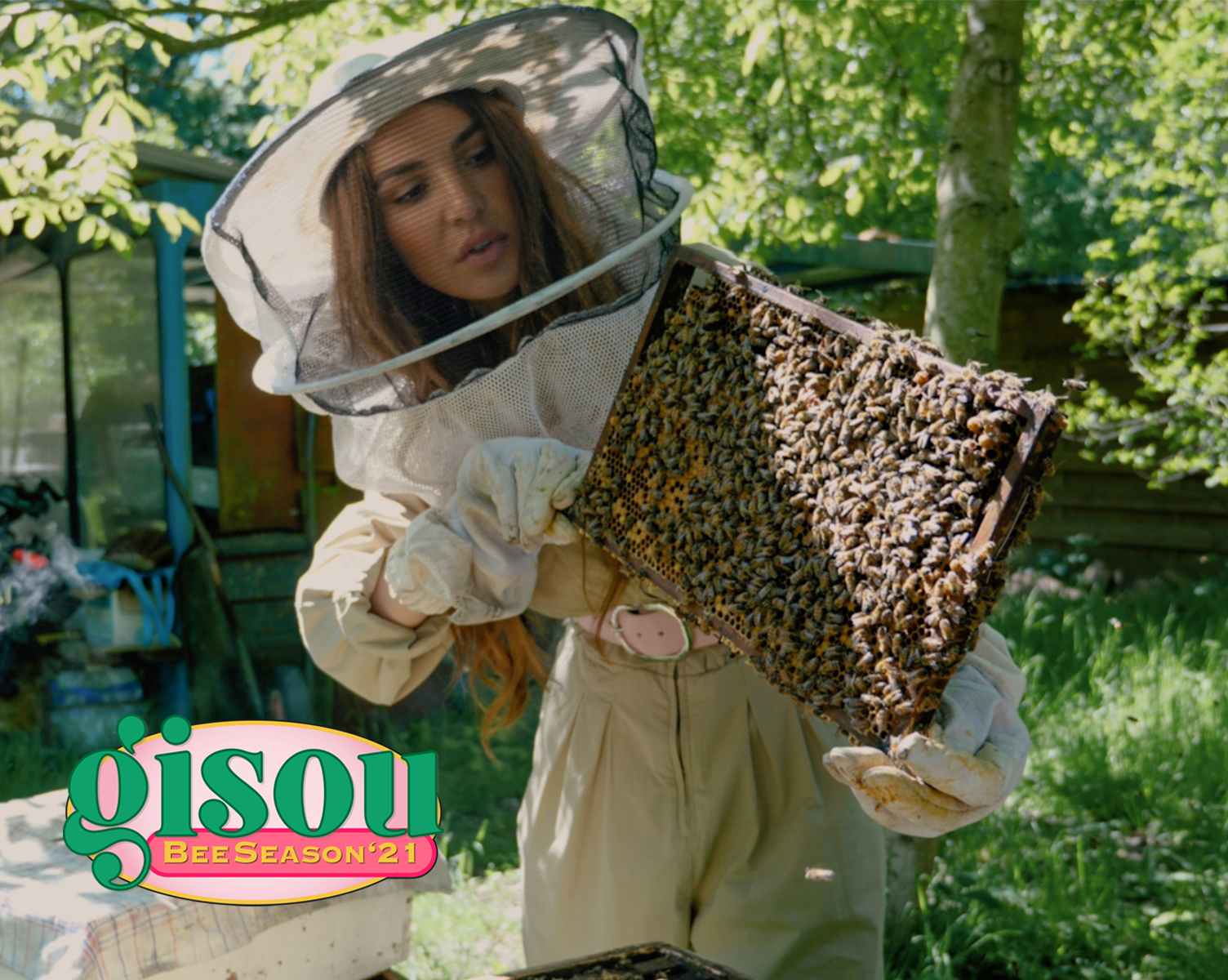 Negin in the bee garden holding a tray of bees