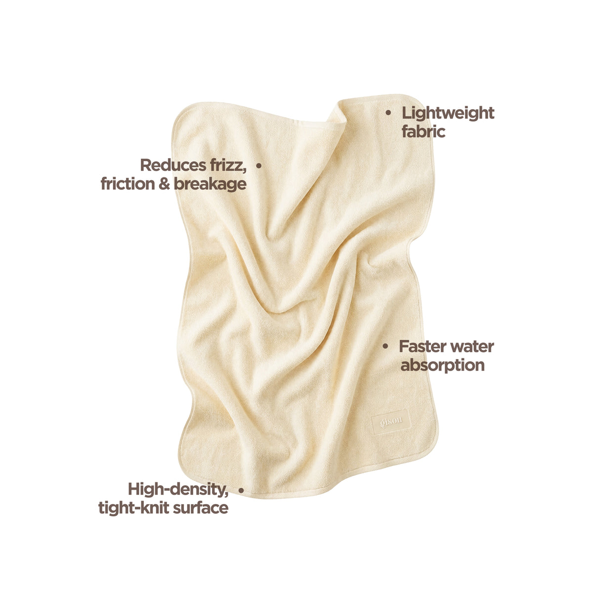 Gisou Honey Gloss Microfiber Hair Towel unfolded, showing its texture, labeled for reducing frizz, fast water absorption, and lightweight fabric.