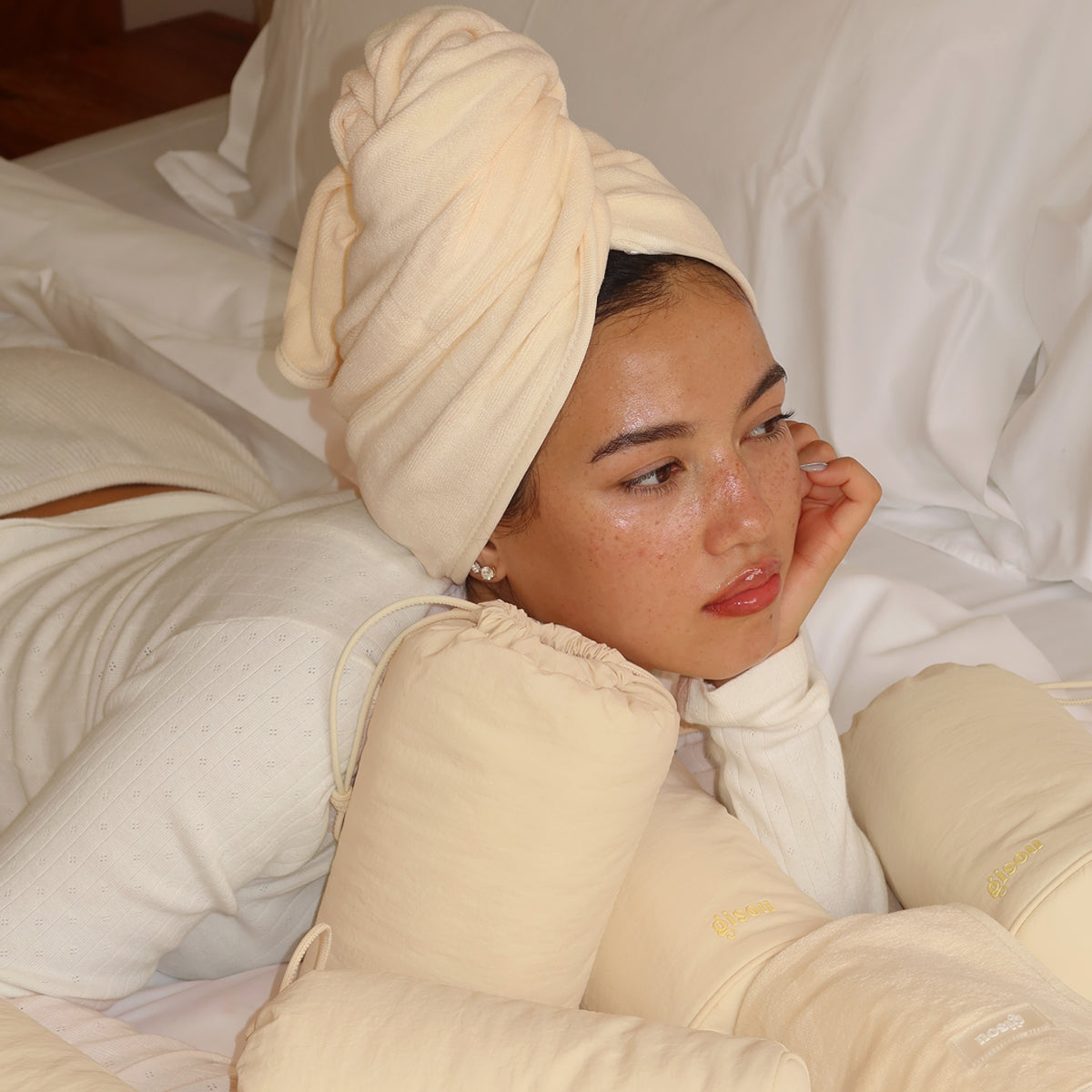 Model wearing the Gisou Honey Gloss Microfiber Hair Towel wrapped around her head.
