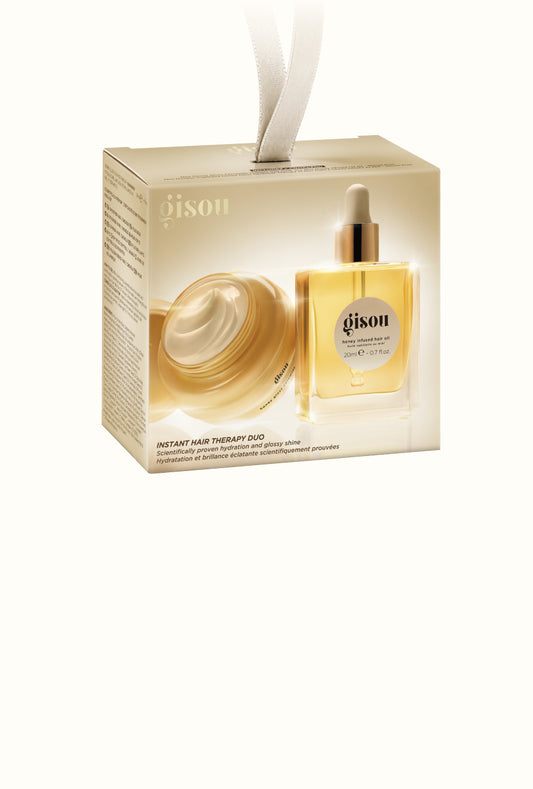 Gisou Instant Hair Therapy Duo holiday gift box with a ribbon loop, showing the mini hair mask and hair oil inside.