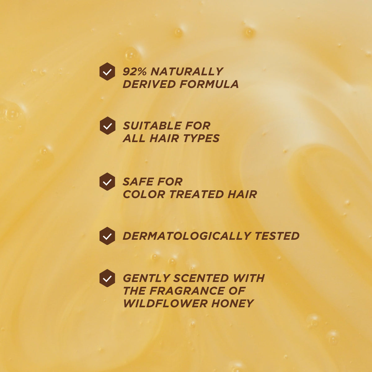 Honey-textured background with key product benefits including naturally derived formula, suitability for all hair types, colour-safe use, and dermatological testing.
